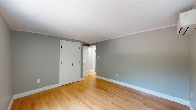 112 Cranberry Ridge Rd, Glocester, RI 02857 - spare room with a wall unit AC, light wood-style floors, ornamental molding, and a textured ceiling