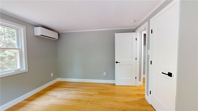 112 Cranberry Ridge Rd, Glocester, RI 02857 - unfurnished room with a wall mounted air conditioner, light wood finished floors, a textured ceiling, a smoke detector, and ornamental molding