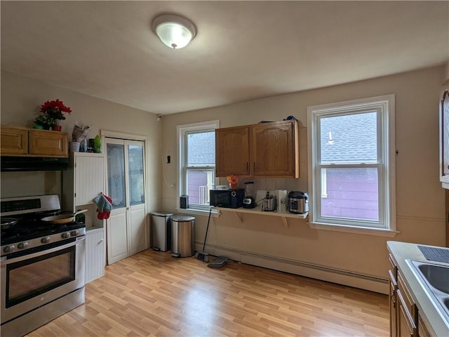60 Sherman St, Pawtucket, RI 02860 - kitchen featuring stainless steel range with gas cooktop, under cabinet range hood, light wood finished floors, a baseboard heating unit, and black microwave