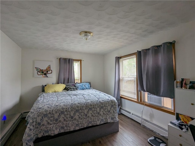 60 Sherman St, Pawtucket, RI 02860 - bedroom featuring a baseboard heating unit, multiple windows, wood finished floors, and a textured ceiling