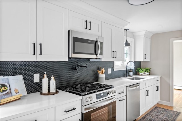 60 Webb Ave, Warwick, RI 02889 - kitchen featuring appliances with stainless steel finishes, light countertops, white cabinetry, backsplash, and light wood-style floors