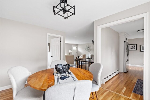60 Webb Ave, Warwick, RI 02889 - dining area featuring a baseboard heating unit, light wood-style flooring, and a chandelier