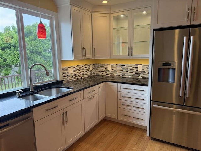 30 Hoover St, West Warwick, RI 02893 - kitchen featuring stainless steel appliances, light wood-style flooring, tasteful backsplash, hanging light fixtures, and white cabinets