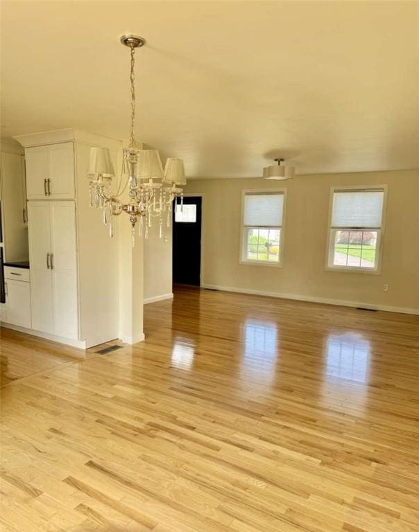 30 Hoover St, West Warwick, RI 02893 - unfurnished dining area featuring light wood-style flooring and a chandelier