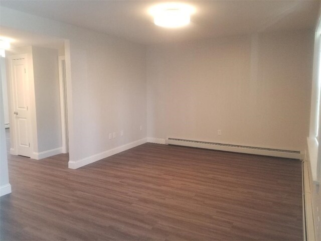 28 Portland St, Providence, RI 02907 - unfurnished room featuring a baseboard radiator, dark wood finished floors, and a baseboard heating unit