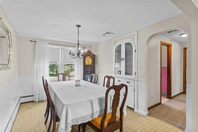 122 Cannon St, Cranston, RI 02920 - dining room with a chandelier, baseboard heating, light colored carpet, arched walkways, and crown molding