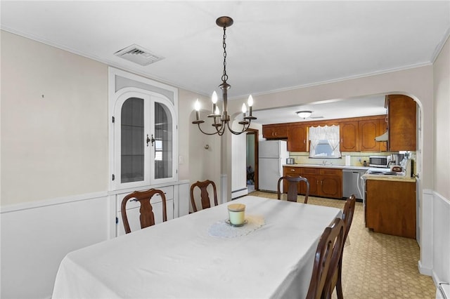 122 Cannon St, Cranston, RI 02920 - dining area featuring arched walkways, a chandelier, ornamental molding, and baseboard heating
