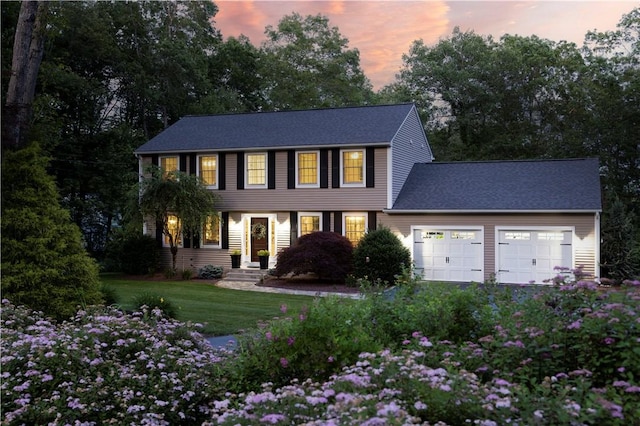 31 Wickaboxet Dr, West Greenwich, RI 02817 - view of front of home featuring an attached garage, a front yard, view of wooded area, and roof with shingles