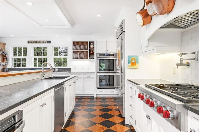 1049 Matunuck Schoolhouse Rd, South Kingstown, RI 02879 - kitchen with stainless steel appliances, white cabinets, dark countertops, tasteful backsplash, and recessed lighting