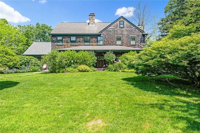 1049 Matunuck Schoolhouse Rd, South Kingstown, RI 02879 - rear view of house with a chimney and a lawn