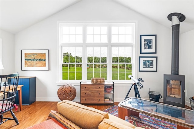 1049 Matunuck Schoolhouse Rd, South Kingstown, RI 02879 - bedroom with a wood stove, vaulted ceiling, wood finished floors, and multiple windows