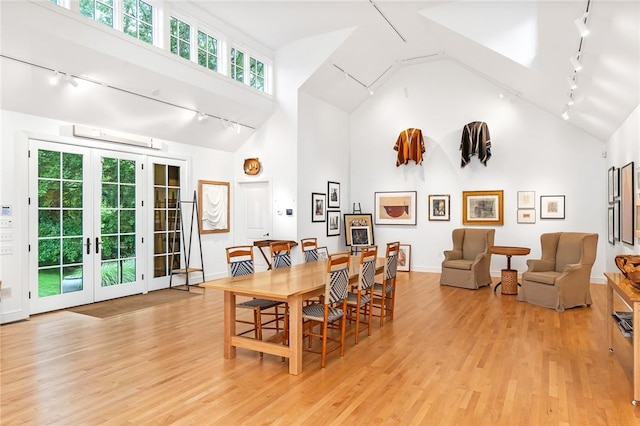 1049 Matunuck Schoolhouse Rd, South Kingstown, RI 02879 - dining area with rail lighting, light wood-style floors, high vaulted ceiling, and french doors