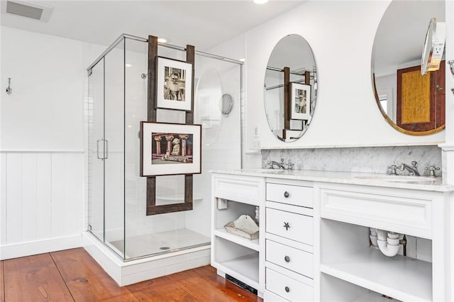 1049 Matunuck Schoolhouse Rd, South Kingstown, RI 02879 - bathroom with a shower stall, double vanity, wood finished floors, and wainscoting