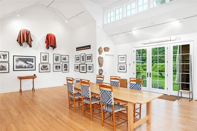1049 Matunuck Schoolhouse Rd, South Kingstown, RI 02879 - dining area featuring track lighting, french doors, light wood finished floors, and high vaulted ceiling