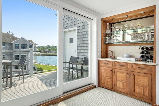 31 Coddington Unit 24, Newport, RI 02840 - indoor wet bar featuring a water view, decorative backsplash, and light carpet