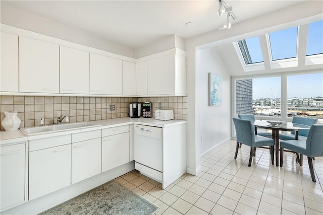 31 Coddington Unit 24, Newport, RI 02840 - kitchen featuring dishwasher, tasteful backsplash, light countertops, a skylight, and white cabinetry
