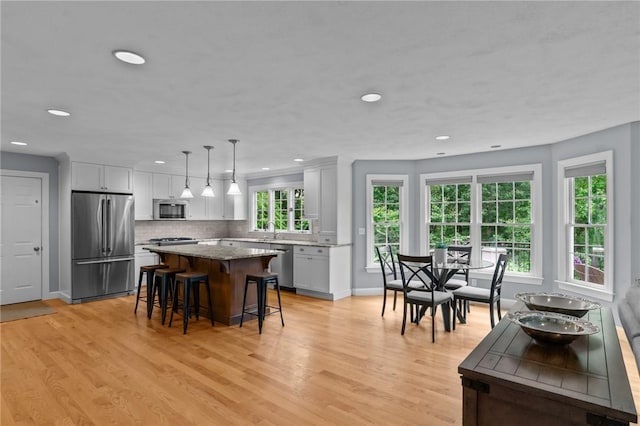 6 Jasons Grant Dr, Cumberland, RI 02864 - kitchen featuring appliances with stainless steel finishes, a kitchen island, a kitchen breakfast bar, light wood-style flooring, and recessed lighting