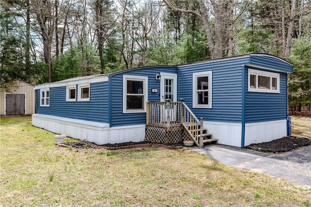 56 Park Ln, Coventry, RI 02816 - manufactured / mobile home with a front yard, view of scattered trees, and an outbuilding