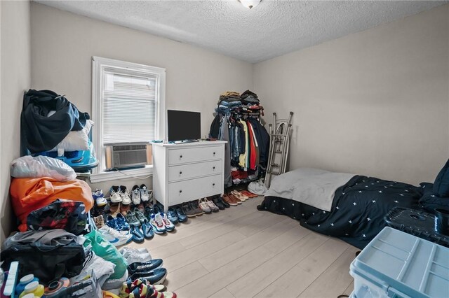 76 Slater St, Pawtucket, RI 02860 - bedroom with cooling unit, wood finished floors, and a textured ceiling