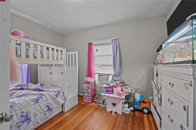 76 Slater St, Pawtucket, RI 02860 - bedroom with wood finished floors, a textured ceiling, and a baseboard heating unit