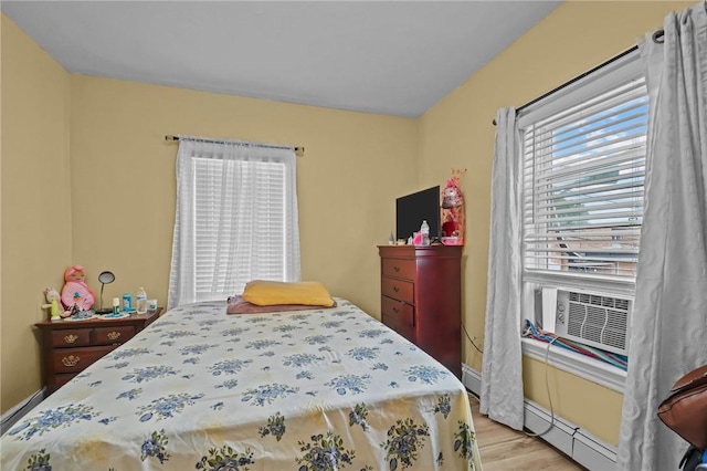 76 Slater St, Pawtucket, RI 02860 - bedroom with light wood-type flooring, baseboard heating, and cooling unit