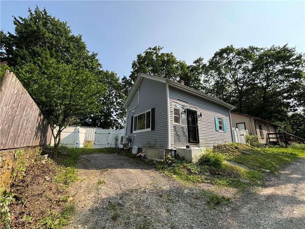 16 Mayor Ln, Warwick, RI 02889 - view of front facade with a gate and a chimney