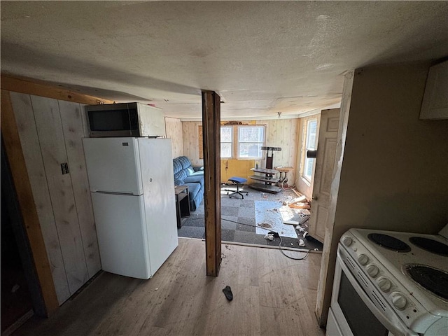 965 Main St, Hopkinton, RI 02832 - kitchen with white appliances, wood finished floors, wooden walls, and a textured ceiling