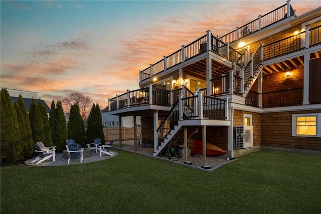 81 S Pier Rd, Narragansett, RI 02882 - back of property at dusk featuring stairway, a patio, a lawn, and a fire pit