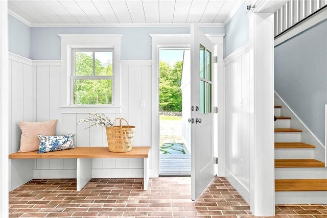 420 Long Hwy, Little Compton, RI 02837 - doorway to outside featuring brick floors, a wainscoted wall, stairway, a decorative wall, and ornamental molding