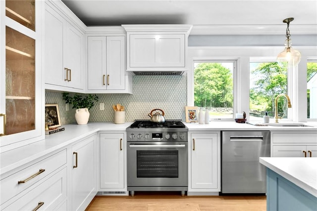 420 Long Hwy, Little Compton, RI 02837 - kitchen featuring appliances with stainless steel finishes, white cabinets, light countertops, backsplash, and decorative light fixtures