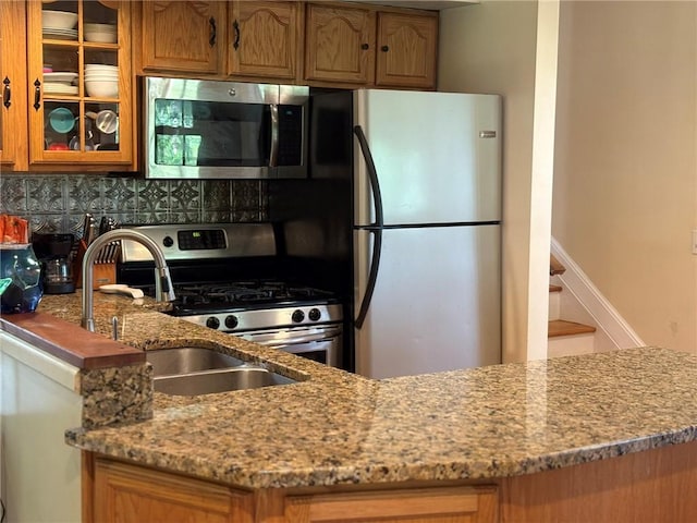 40 Anthony Rd, Foster, RI 02825 - kitchen with stainless steel appliances, light stone countertops, decorative backsplash, glass insert cabinets, and brown cabinetry