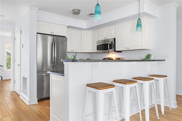 20 Narragansett Ave Unit 404, Narragansett, RI 02882 - kitchen with appliances with stainless steel finishes, light wood finished floors, white cabinets, a kitchen bar, and crown molding