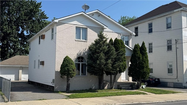 179 Wallace St, Providence, RI 02909 - view of front of house featuring a detached garage, an outbuilding, and brick siding