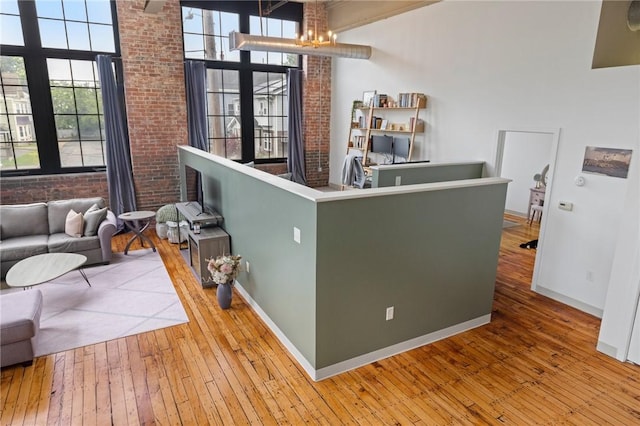 685 Social St Unit 114, Woonsocket, RI 02895 - bar with hardwood / wood-style floors, a high ceiling, a chandelier, and brick wall