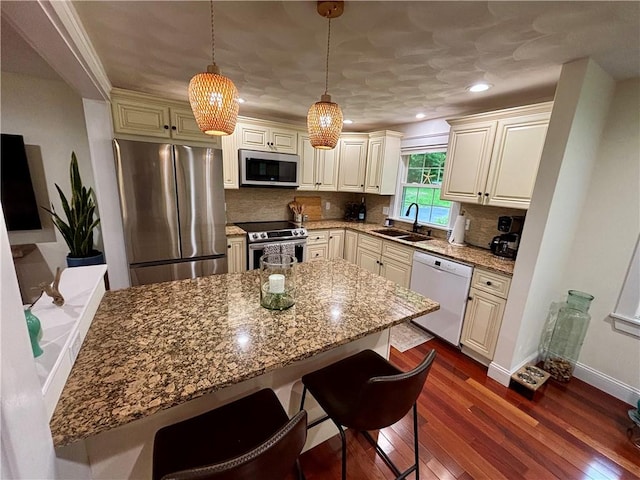 10 Lakeside Dr, Charlestown, RI 02813 - kitchen with appliances with stainless steel finishes, a breakfast bar, dark wood-type flooring, light stone counters, and backsplash