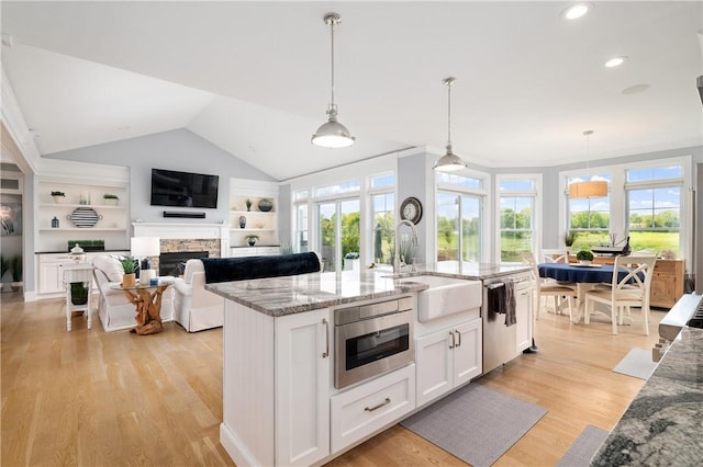 155 E Matunuck Farm Dr, South Kingstown, RI 02879 - kitchen featuring dishwasher, white cabinets, a fireplace, light wood-style floors, and healthy amount of natural light
