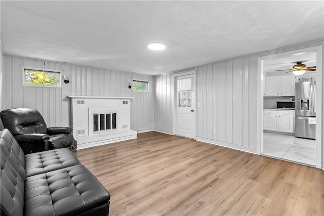 211 Tiogue Ave, Coventry, RI 02816 - living room featuring light wood-type flooring, a brick fireplace, and a ceiling fan