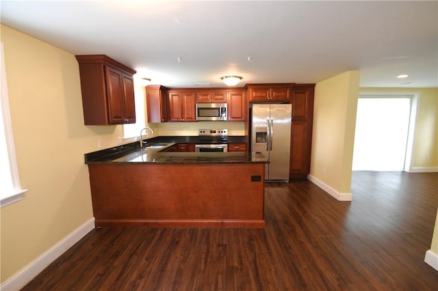 92 Trout Dr, Middletown, RI 02842 - kitchen with stainless steel appliances, a peninsula, dark wood-type flooring, recessed lighting, and dark stone counters