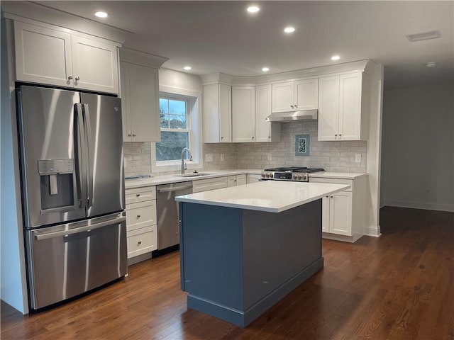 59 Recess Ln, Warwick, RI 02889 - kitchen featuring stainless steel appliances, light countertops, dark wood-style floors, under cabinet range hood, and tasteful backsplash