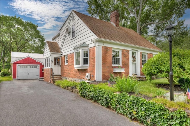 426 Buxton St, North Smithfield, RI 02896 - view of front of home featuring a chimney, brick siding, a garage, asphalt driveway, and an outdoor structure