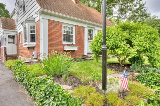 426 Buxton St, North Smithfield, RI 02896 - view of property exterior with entry steps, brick siding, a shingled roof, and a chimney