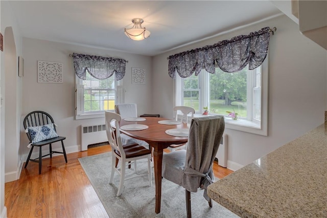 426 Buxton St, North Smithfield, RI 02896 - dining area with plenty of natural light, radiator heating unit, and light wood-style floors