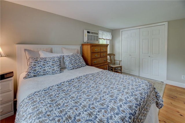 426 Buxton St, North Smithfield, RI 02896 - bedroom with wood finished floors, a wall unit AC, and a closet