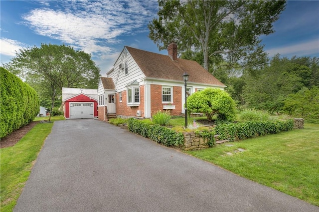 426 Buxton St, North Smithfield, RI 02896 - view of front facade featuring brick siding, a garage, a chimney, driveway, and a front yard
