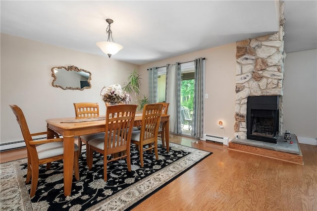 2970 Mendon Rd Unit 154, Cumberland, RI 02864 - dining area featuring wood finished floors, a fireplace, and a baseboard radiator