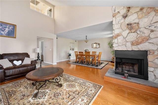 2970 Mendon Rd Unit 154, Cumberland, RI 02864 - living area featuring wood finished floors, baseboard heating, a towering ceiling, and a fireplace