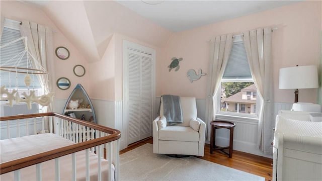 280 Woodbine St, Cranston, RI 02910 - bedroom featuring wood finished floors, a closet, a wainscoted wall, a nursery area, and vaulted ceiling
