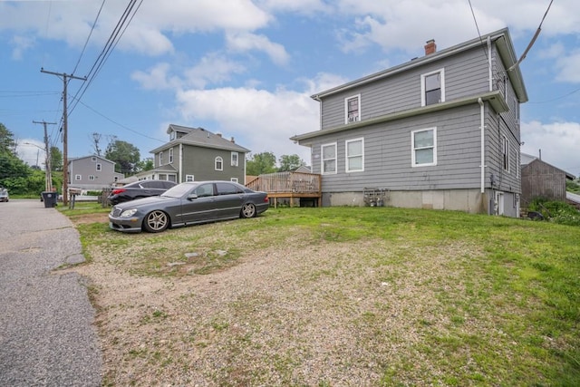 12 Lenox St, Cumberland, RI 02864 - back of property with a chimney, a lawn, and a wooden deck