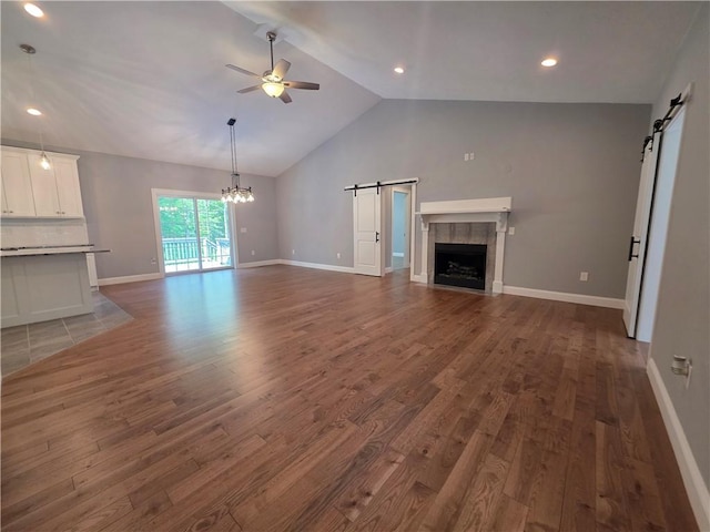 475 Danielson Pike, Scituate, RI 02857 - unfurnished living room featuring a barn door, a ceiling fan, a chandelier, lofted ceiling, and a tiled fireplace