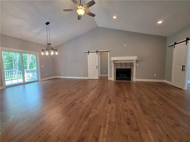 475 Danielson Pike, Scituate, RI 02857 - unfurnished living room featuring a barn door, dark wood finished floors, a ceiling fan, vaulted ceiling, and a tiled fireplace